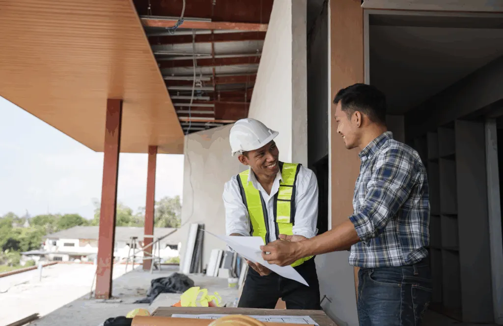 Builder and project manager in construction meeting reviewing schedule